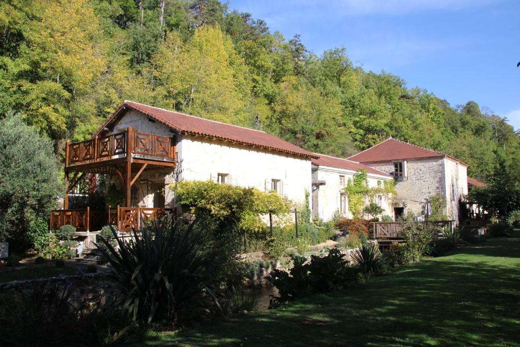a house with a deck on the side of it at Moulin des Faurilloux in La Chapelle-Faucher