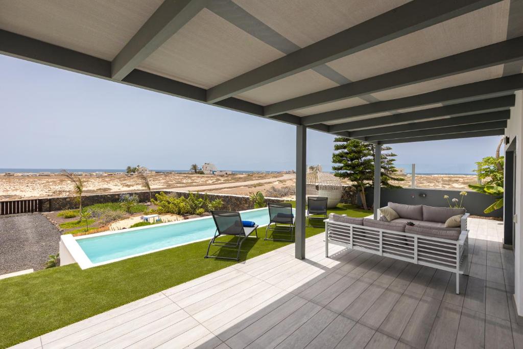 a patio with a view of a swimming pool at Villa Reflejo de Mar in El Cotillo