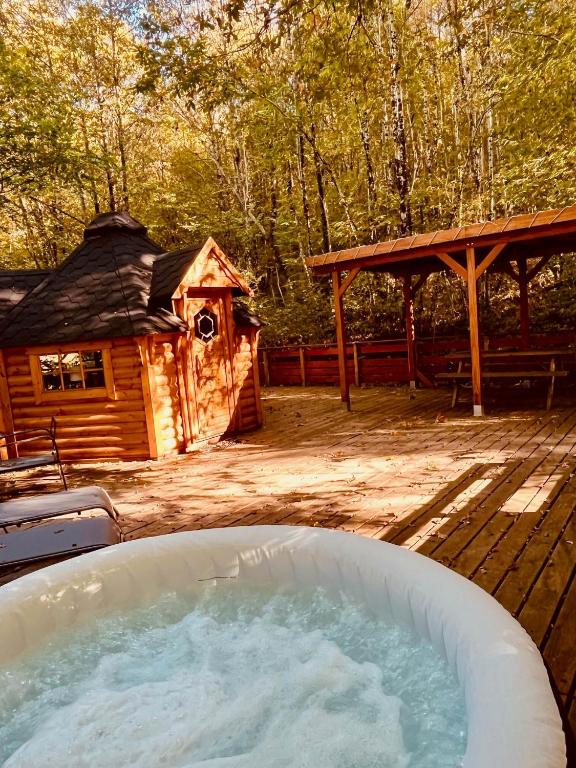 a hot tub in a yard next to a cabin at Aux Étangs de Jourgnac - Kota in Jourgnac