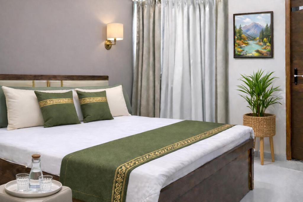 a bedroom with a large bed with a green and white blanket at Ekaay The Boutique Hotel in Kumārkara