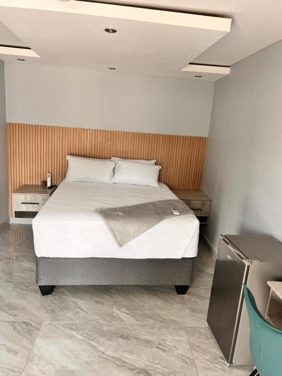 a bedroom with a bed and a wooden wall at Marble Crest Guest House in Maun