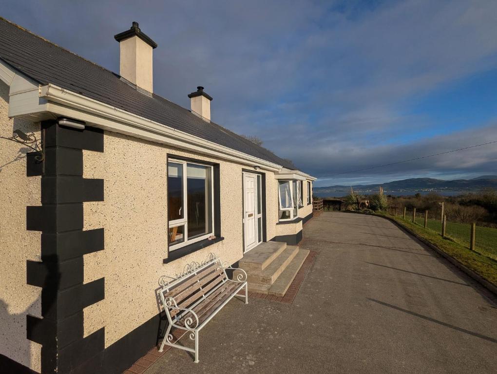 a bench sitting outside of a house with a building at Sea View Heights in Rathmullan