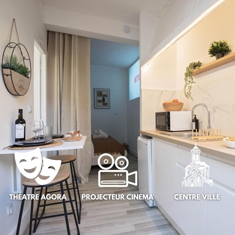 a small kitchen with a counter and a table at Vidéoprojecteur - Tout à pied - Centre - Balcon in Montpellier