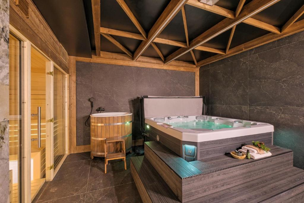 a large bathroom with a tub and a stool at Aparthotel Białka SKI, Odkryj-Bialke in Białka Tatrzańska