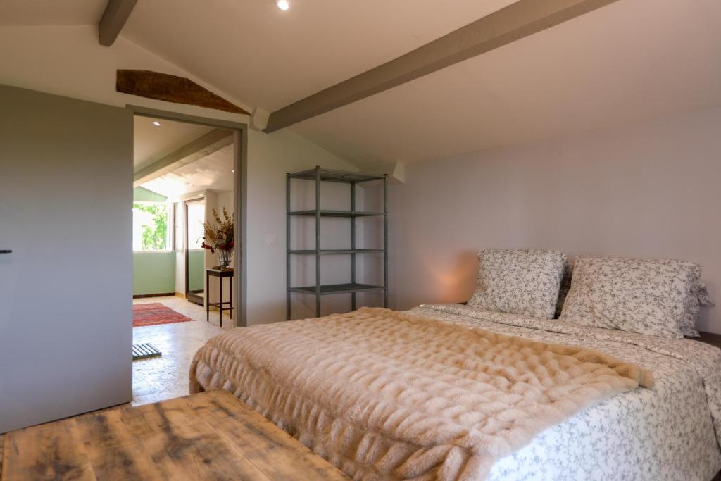 a bedroom with a large bed in a room at Mas des Côtes in Saint-Hippolyte-le-Graveyron