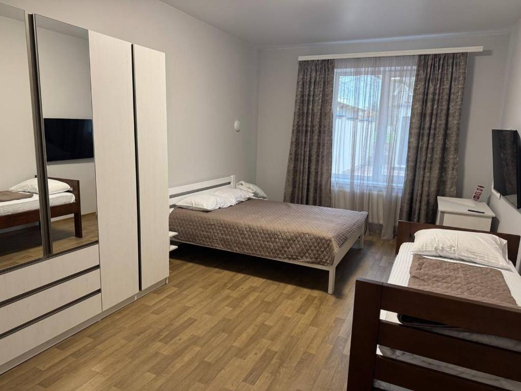 a small bedroom with two beds and a mirror at Надія in Khlibodarske
