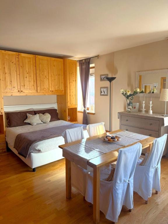 a bedroom with a bed and a table and chairs at Bormio Alpine Home in Bormio