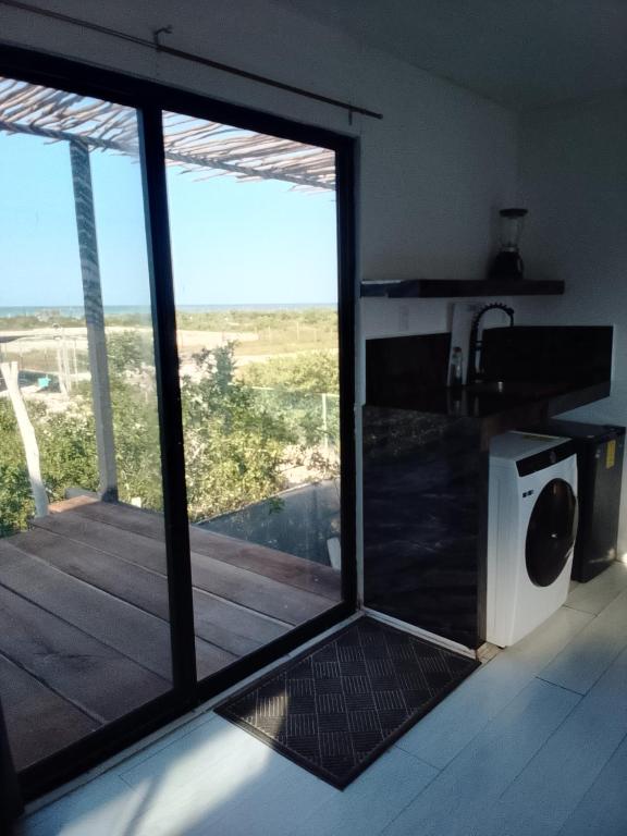 a kitchen with a large glass window with a view of a deck at Container House in Sisal