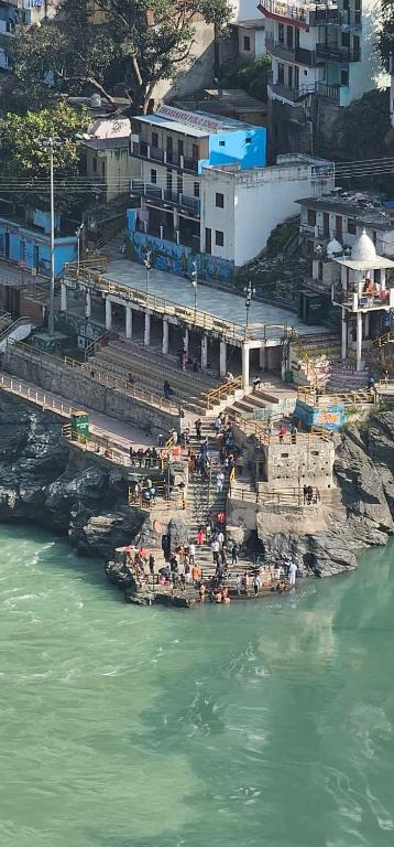 a group of people standing on a pier near the water at Sangam View Homestay Devprayag in Devaprayāg