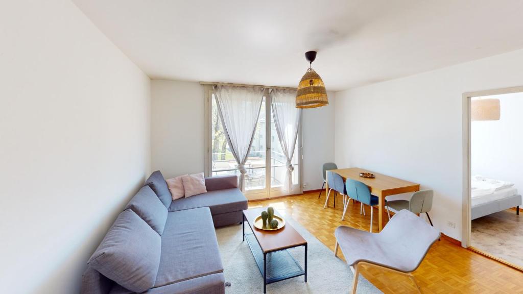 a living room with a couch and a table at Practical Apartment Near Seebach in Zurich