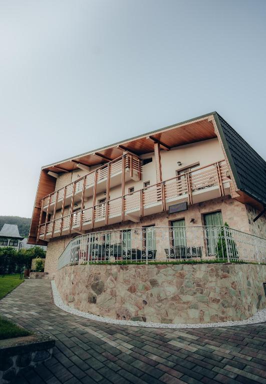 a building with a balcony on the side of it at Casa Cheile Dâmbovicioarei - Cabana 3 in Podu Dîmboviţei