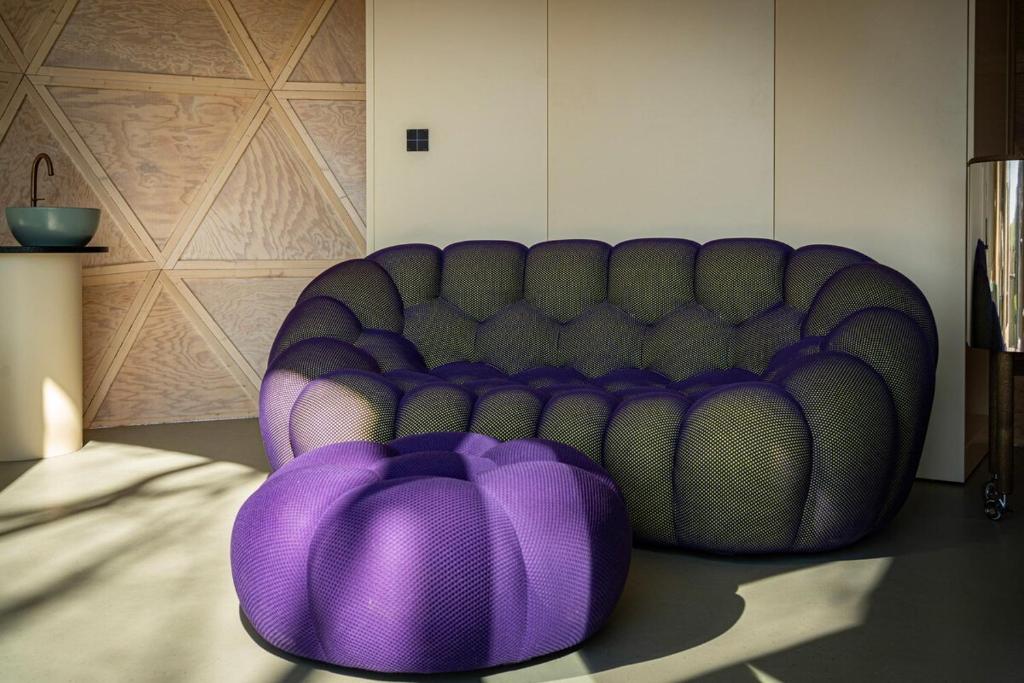 a purple couch sitting in a room with a purple pillow at Echo - Baumhaus K1 in Odenthal