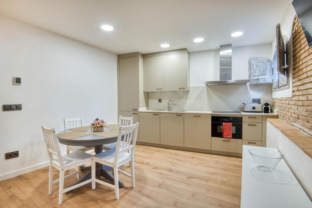 a kitchen and dining room with a table and chairs at Pati Blau 2 in Caldes de Malavella