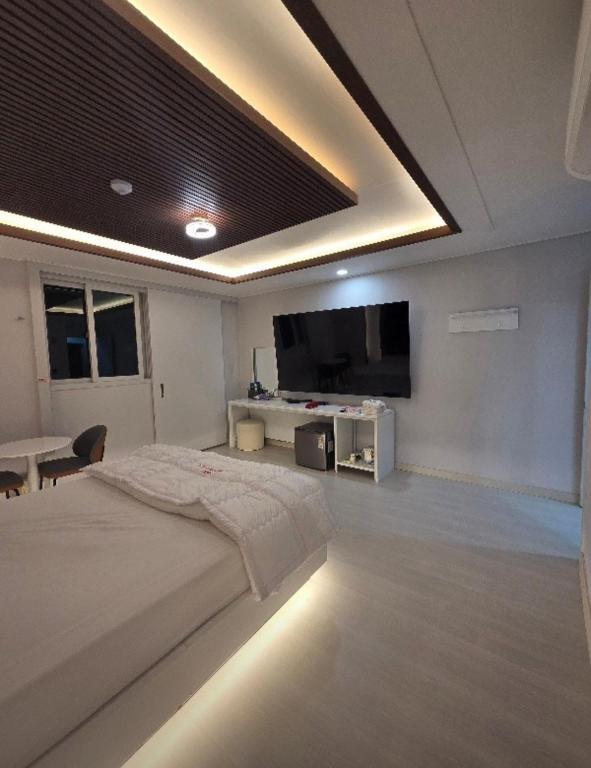 a bedroom with a large bed and a flat screen tv at 벨라지오호텔 in Sagog-yŏk