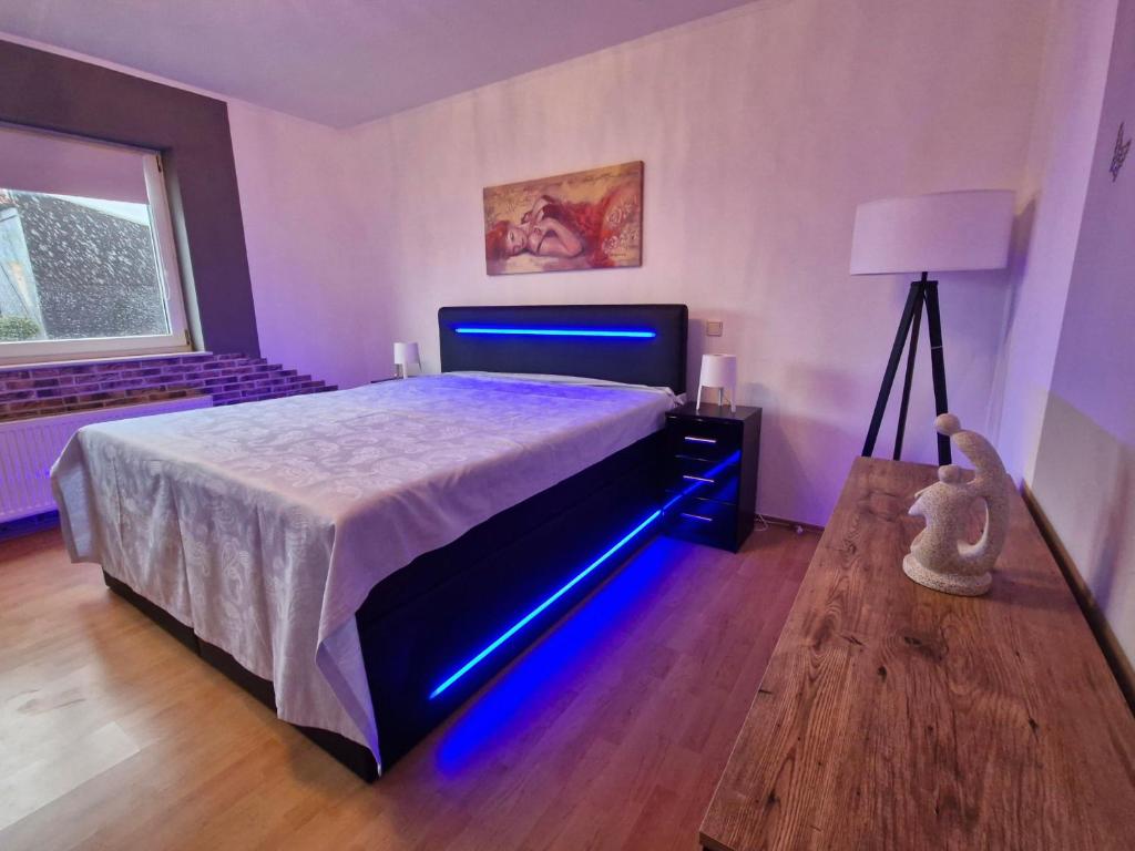 a bedroom with a bed with a blue light on it at Ferienwohnung Roersch in Freudenburg