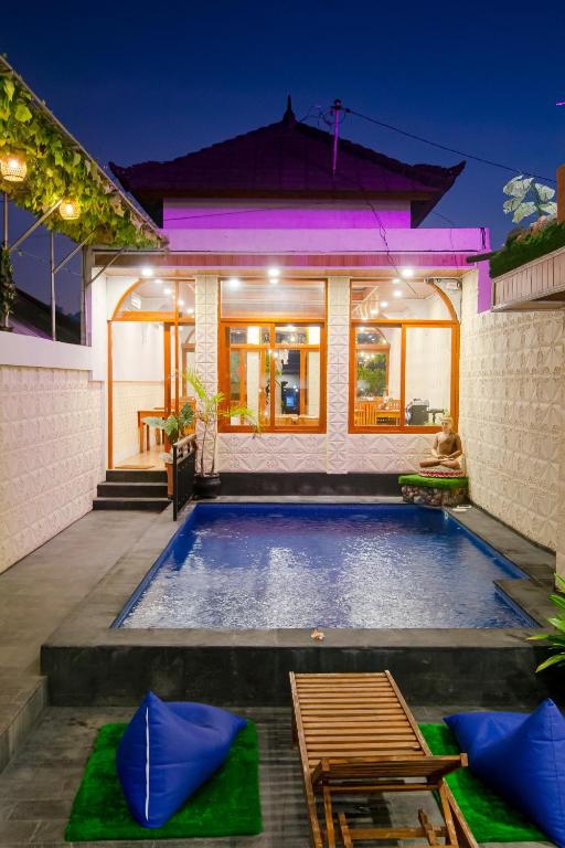 a villa with a swimming pool in front of a house at Eric Dolphin Villa in Lovina