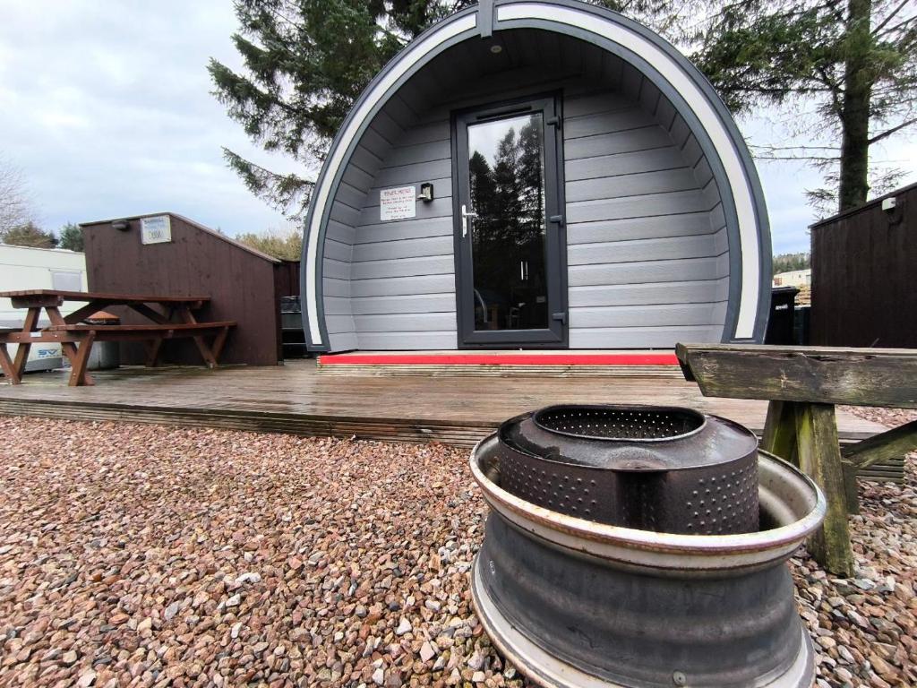 a circular house with a barrel in front of it at Barrhill Holiday Park - Glamping in South West Scotland - Stinchar in Girvan