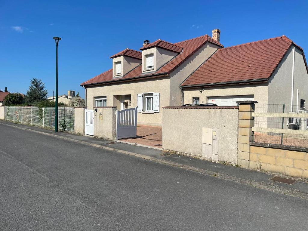 a house on the side of a street with a fence at Macasa chambres et table d'hôte in Coolus