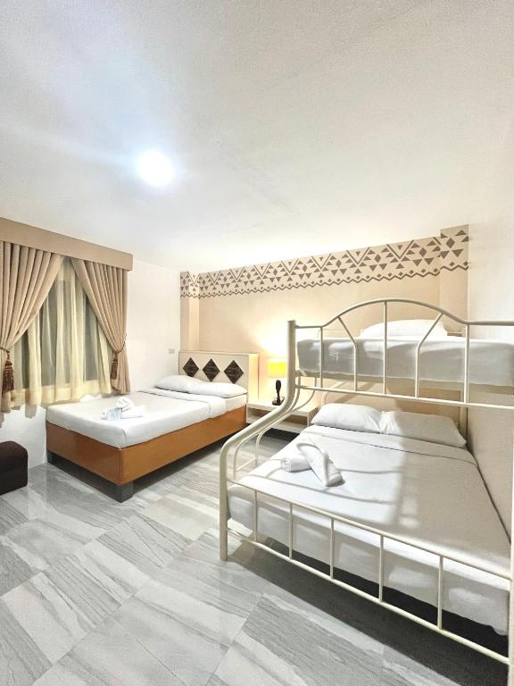 two beds in a large room with two at Bila Boutique Hotel in Lagao II