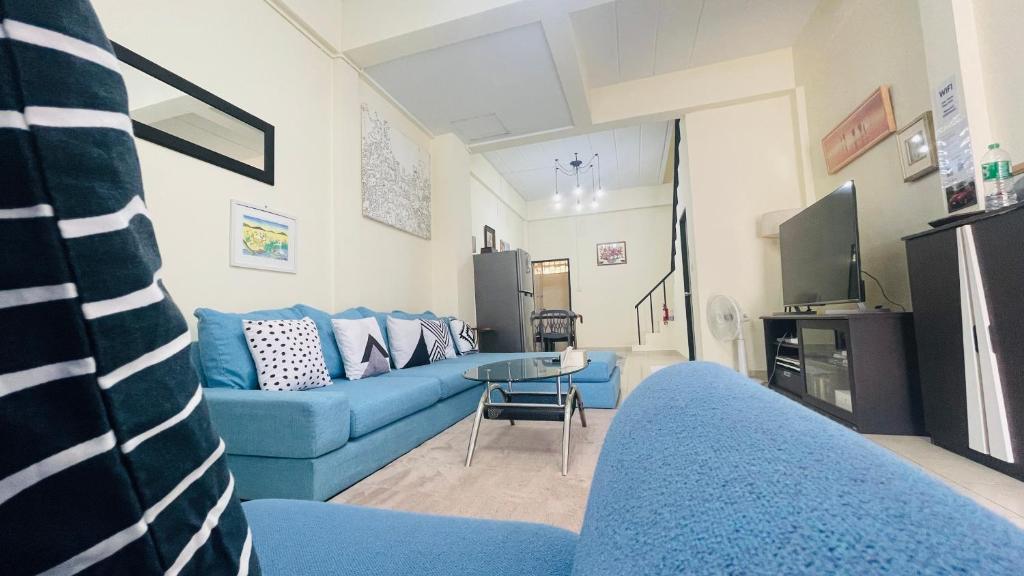 a living room with a blue couch and a tv at Baan Mali one in Hua Hin