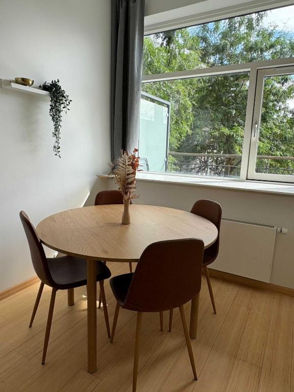 a dining room with a table and chairs and a window at PENDING Queen Bedroom with Balcony in Shared Apartment in Copenhagen