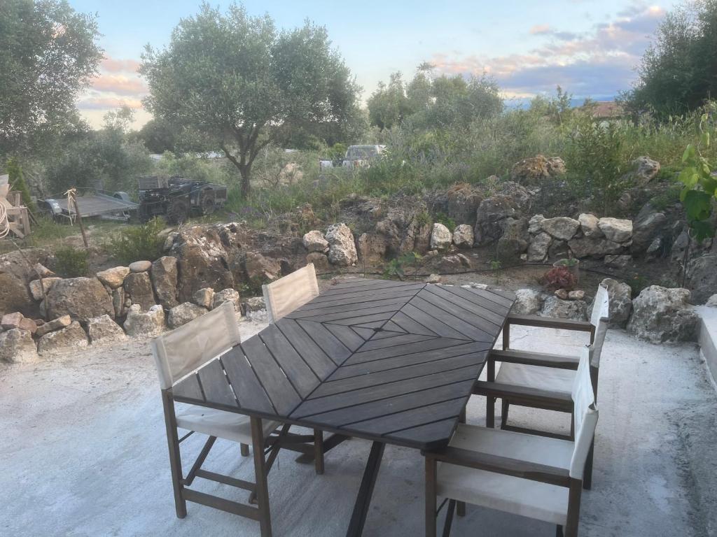 a wooden table and two chairs sitting next to a garden at Casetta Teppe rosse in Aléria