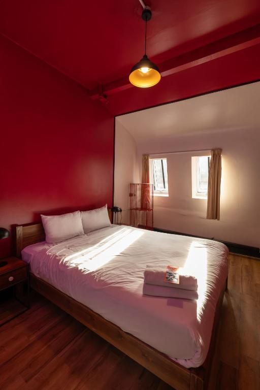 a bedroom with a large bed with a red wall at Malacuna Manchester in Manchester