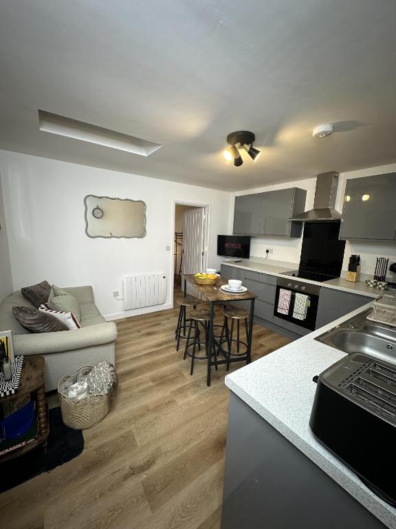 a kitchen and living room with a couch and a table at Rosern Short Stays in St. Ives