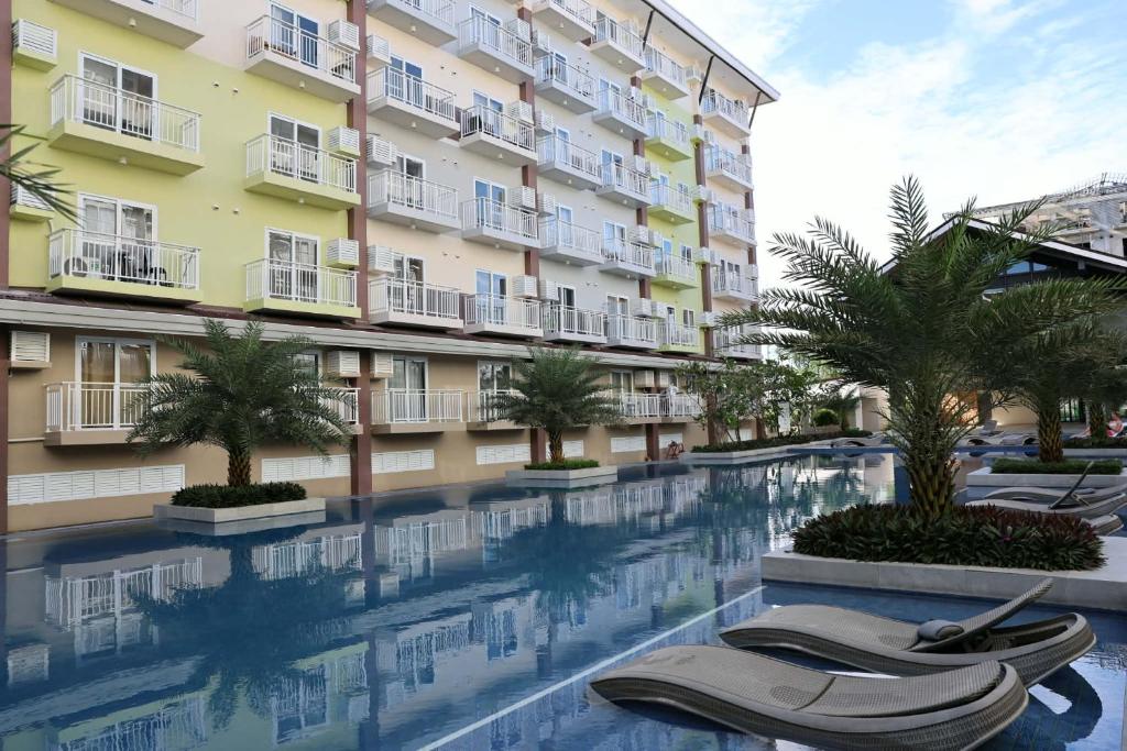 a swimming pool in front of a building at Lolit cozy condo in Lapu Lapu City