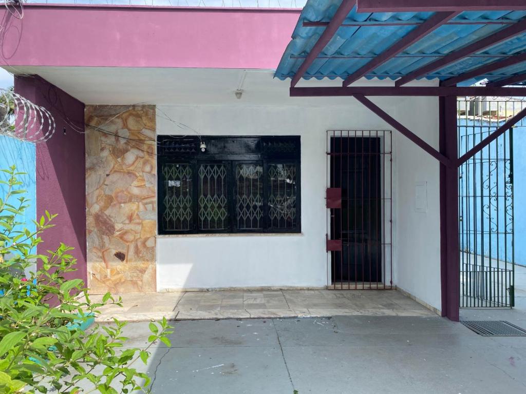 a white building with a black barred window on it at Açaizeiro Hostel in Belém