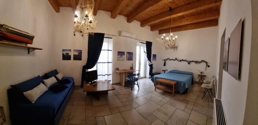 a living room with a blue couch and a bed at B & B Stella Marina in Taranto