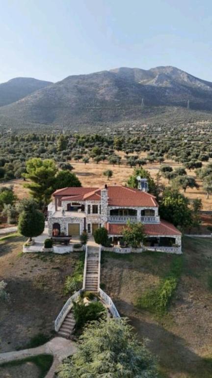 a house on a hill with mountains in the background at Stone Horizon Villa in Eretria