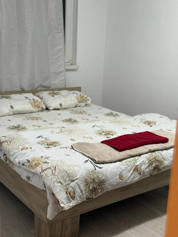 a bed with a blanket and pillows on it at Turda central apartament in Turda