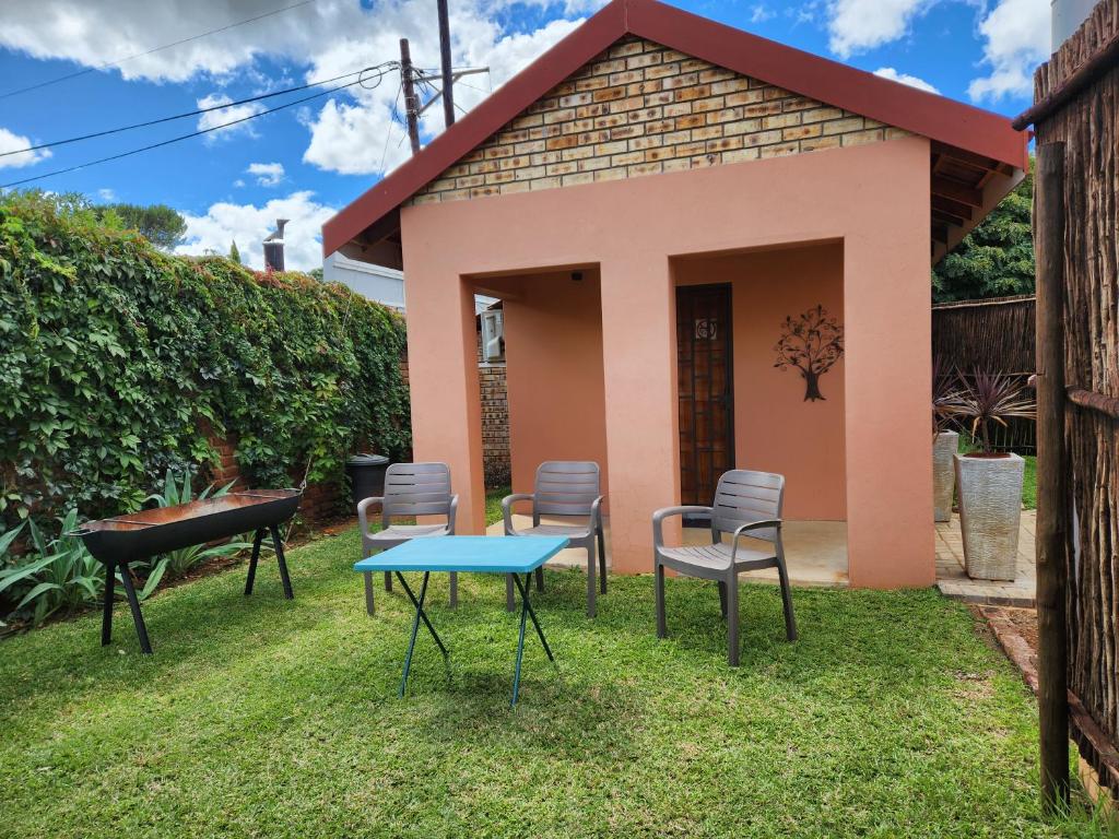 a small pink house with chairs and a table at Lafenis Selfsorg in Jan Kempdorp