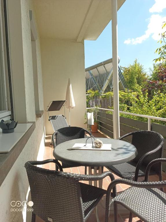 a patio with a table and chairs on a balcony at Gästehaus am Main in Randersacker