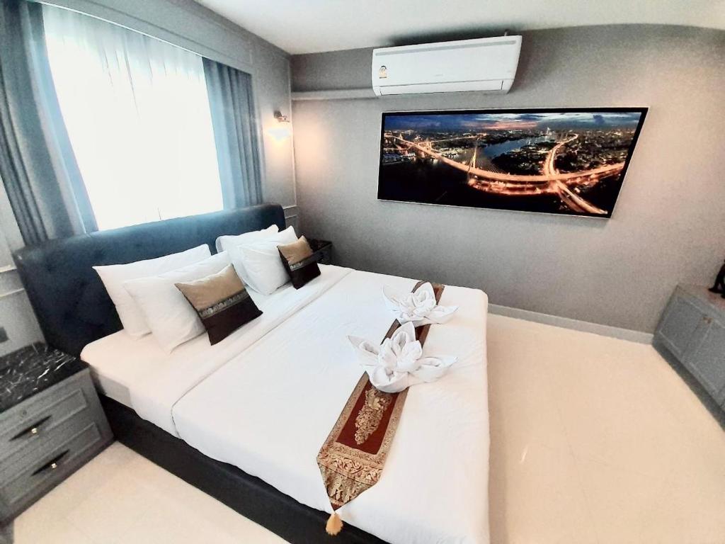 a bedroom with a white bed with a flower on it at Latkrabangbishome Near Suvarnabhumi Airport ลาดกระบังบิซโฮม in Lat Krabang