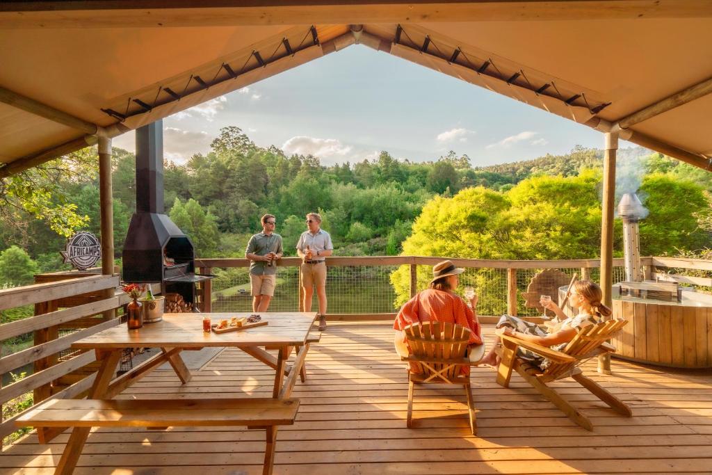 a group of people on a deck with a fireplace at AfriCamps Magoebaskloof in Magoebaskloof