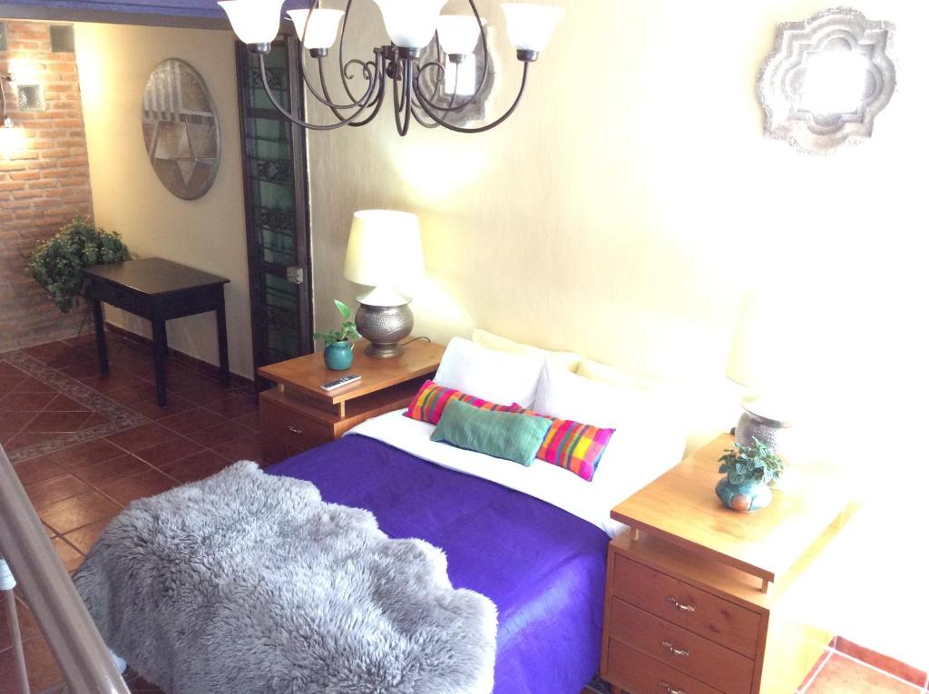 a bedroom with a bed and a chandelier at Casa Bonita in Guadalajara