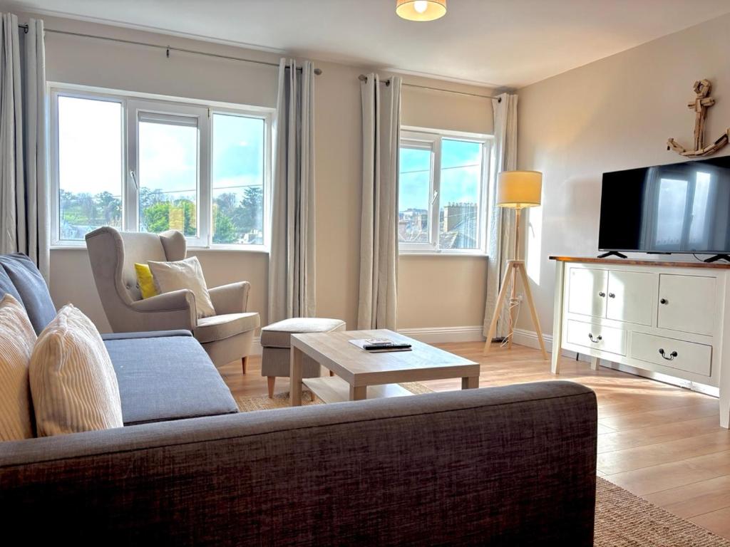 a living room with a couch and a tv at Cobh Coastline Hideaway in Cobh