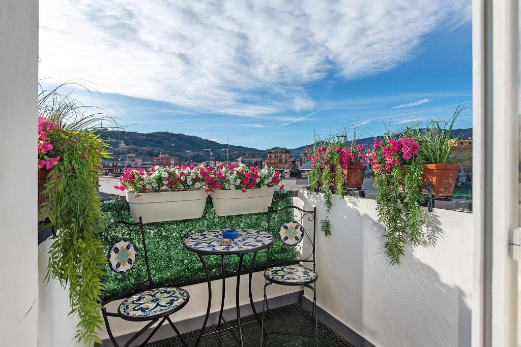 a balcony with potted flowers and tables and chairs at Linda's Pet Friendly Beach House in Rapallo