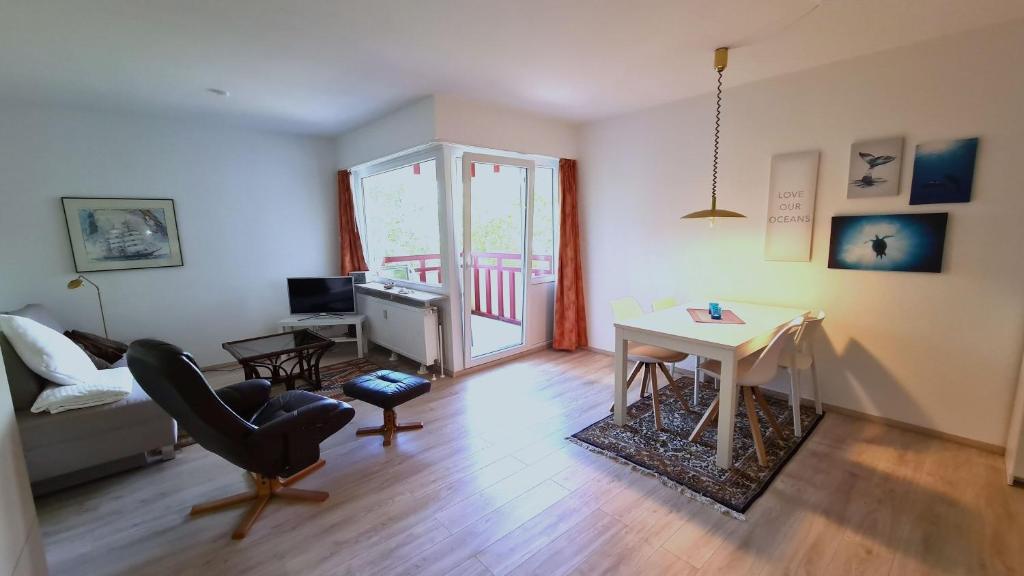a living room with a table and a desk at Terrassenhaus, FeWo 32 in Duhnen