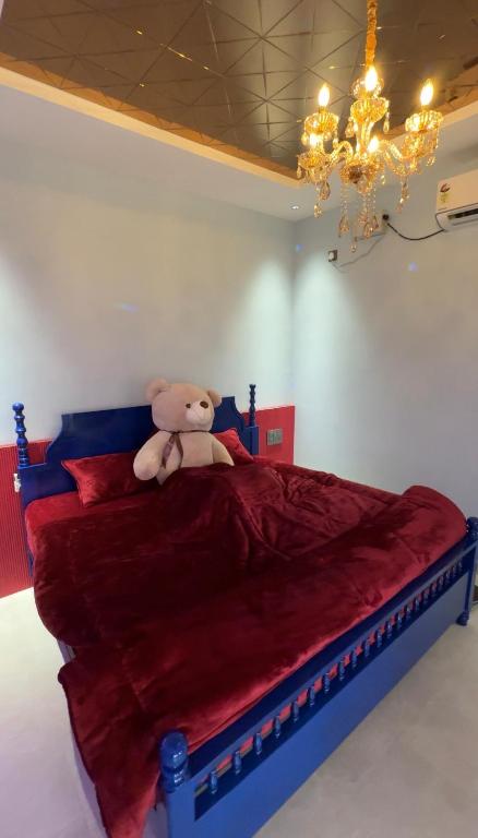 a teddy bear sitting on a bed in a bedroom at Teddy in Malpe