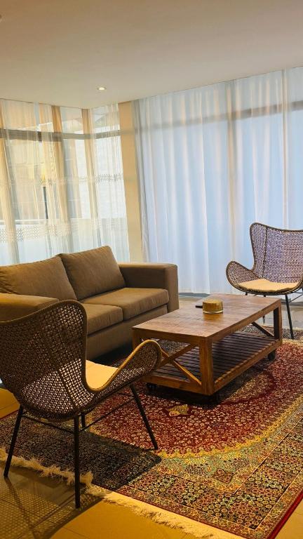 un soggiorno con un divano, un tavolo e delle sedie di Central Windhoek location a Windhoek
