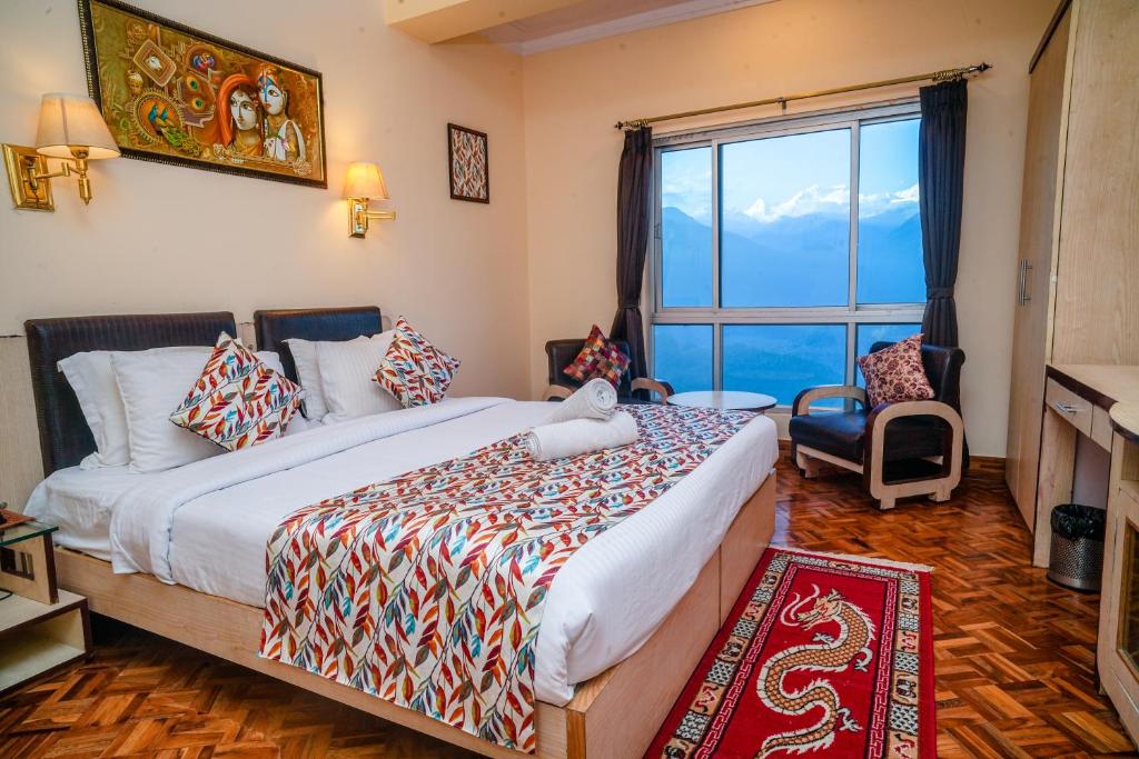 a bedroom with a large bed and a large window at Rare Himalayas De Regency Pelling in Pelling