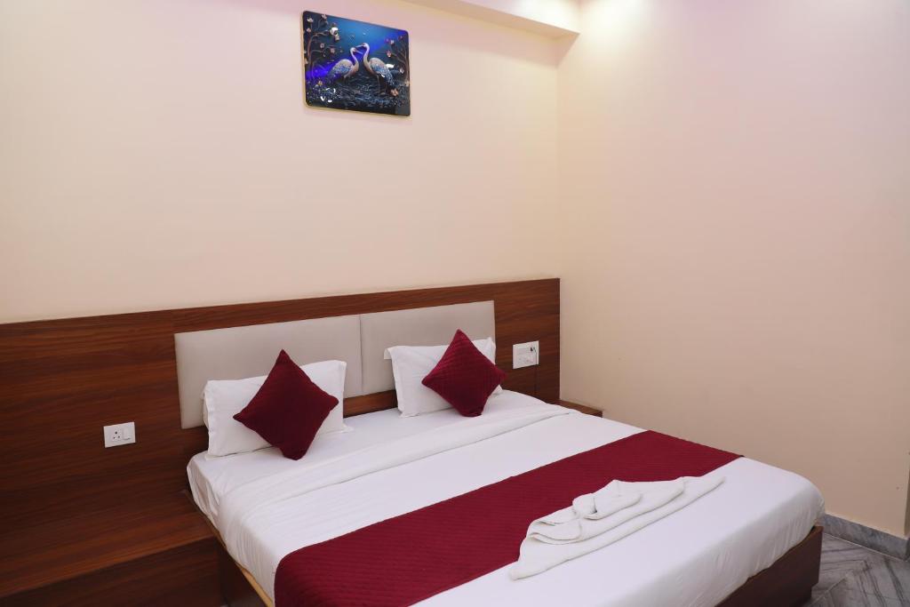 a bedroom with a large white bed with red pillows at Hotel Relax in Jaipur