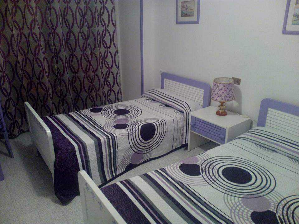 a bedroom with two beds and a lamp on a table at Hostal RIAÑO TANIS in Riaño