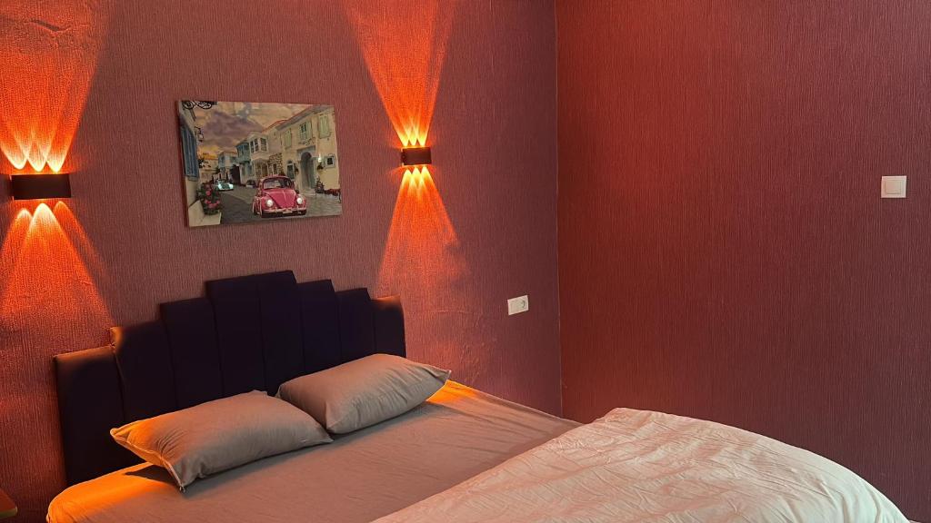 a bedroom with a bed with lights on the wall at Çankaya Otel in Altındağ