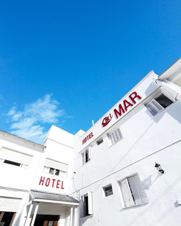 a white hotel with a red sign on top of it at Hotel Che Mar in Necochea