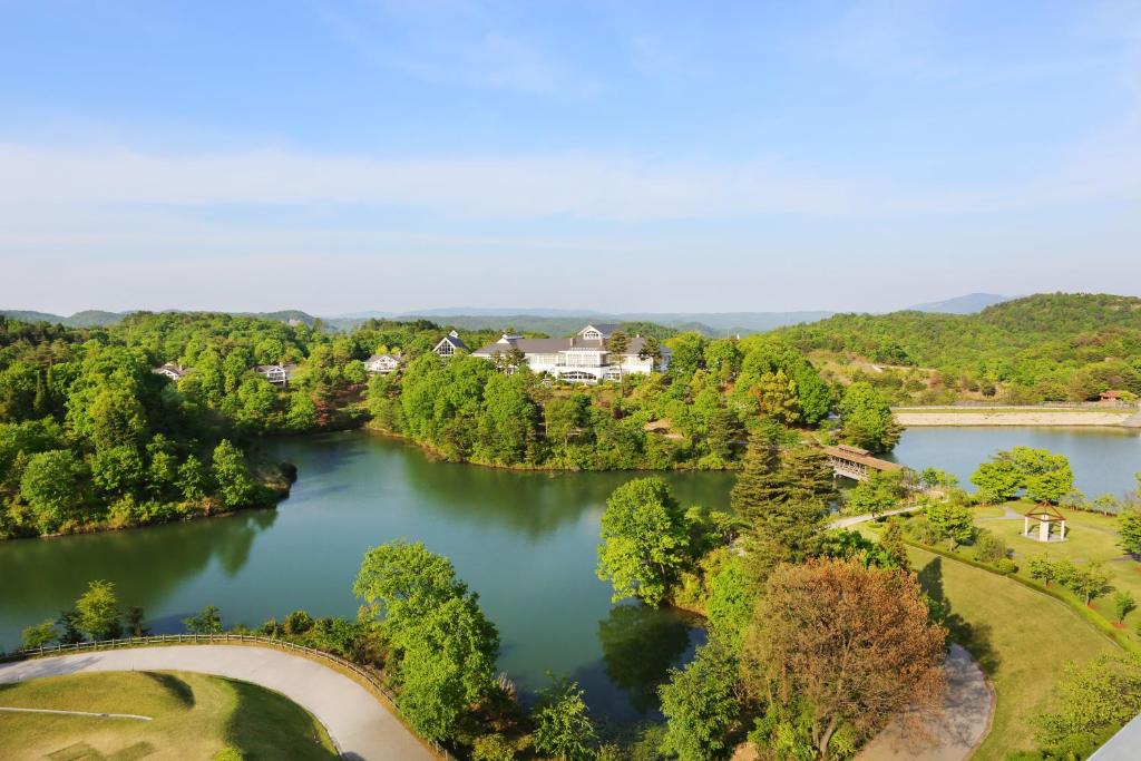 an aerial view of a lake with houses and trees at Forest Hills Garden in Mihara