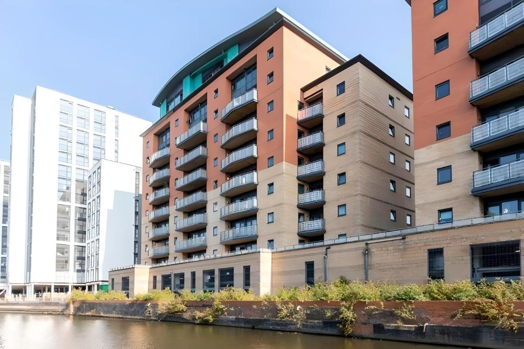a tall apartment building next to a river at Empire Serviced Apartments in Leicester